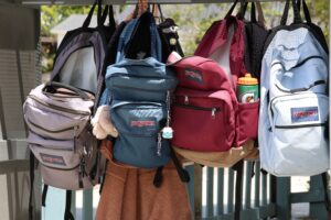 A row of opened school backpacks.